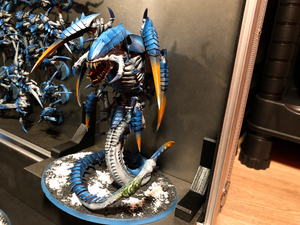 Magnetic brackets holding a large monster miniature in a display case