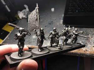 Magnetic infantry tray held in hand with unpainted 25 mm miniatures