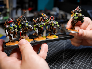 Removing a single Ork Boy miniature from a magnetic infantry tray