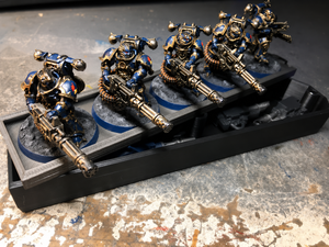 Weapon options box beside a magnetic tray storing a heavy weapons squad loadout